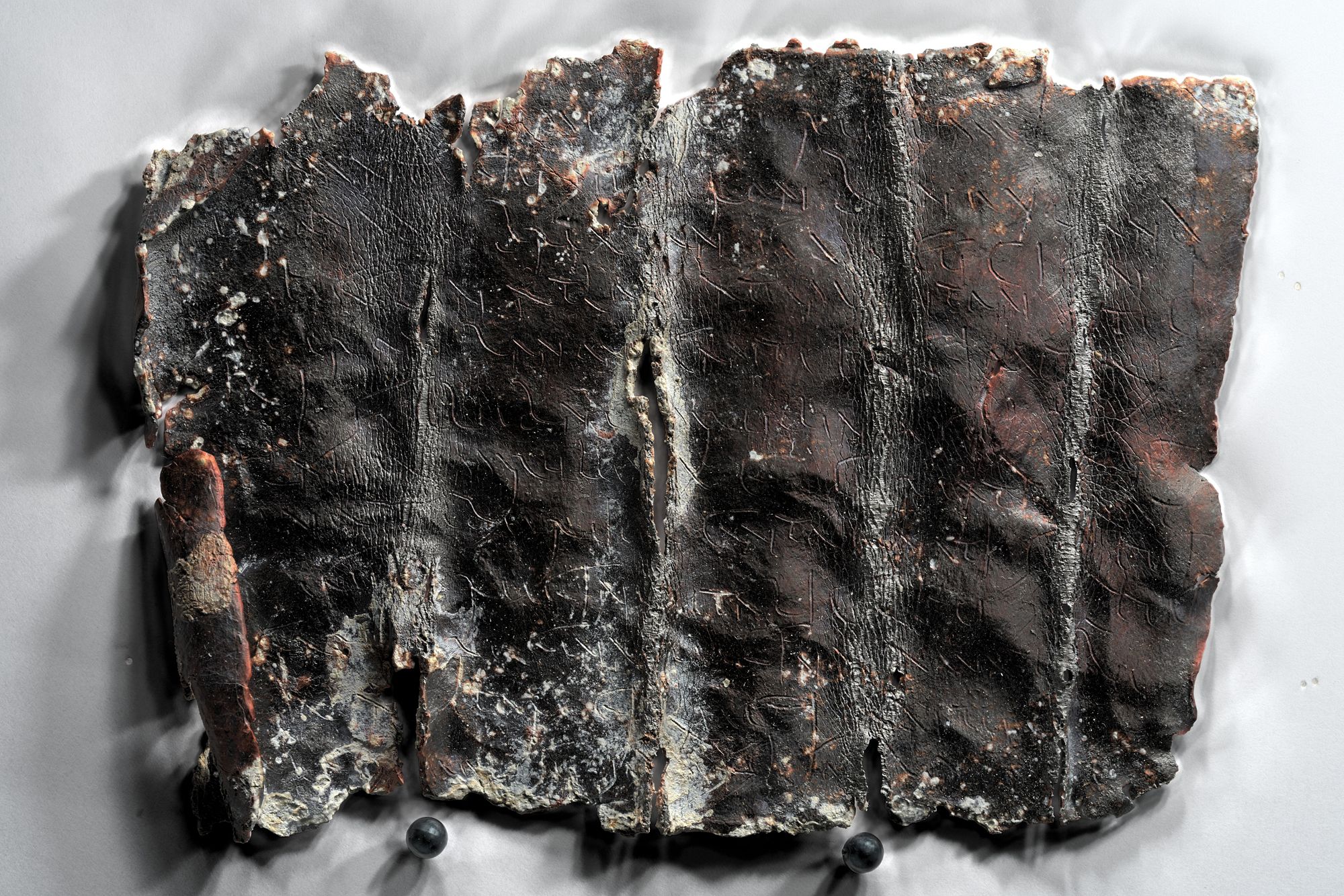 Tablette de défixion en langue gauloise trouvée lors de la fouille de la nécropole antique à l'emplacement de l'ancien hôpital Porte Madeleine (Crédits : Antoine Cazin, la Fabrique de patrimoines en Normandie, 2023)