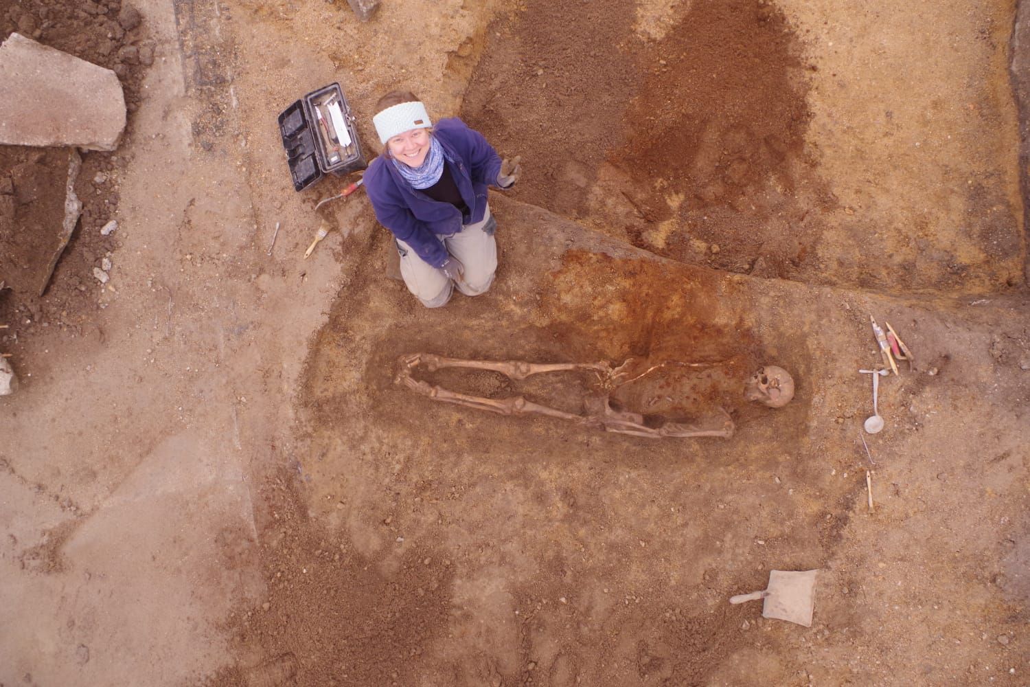 Une archéologue heureuse de fouiller une des dernières sépultures du site (SAVO, 2025). 