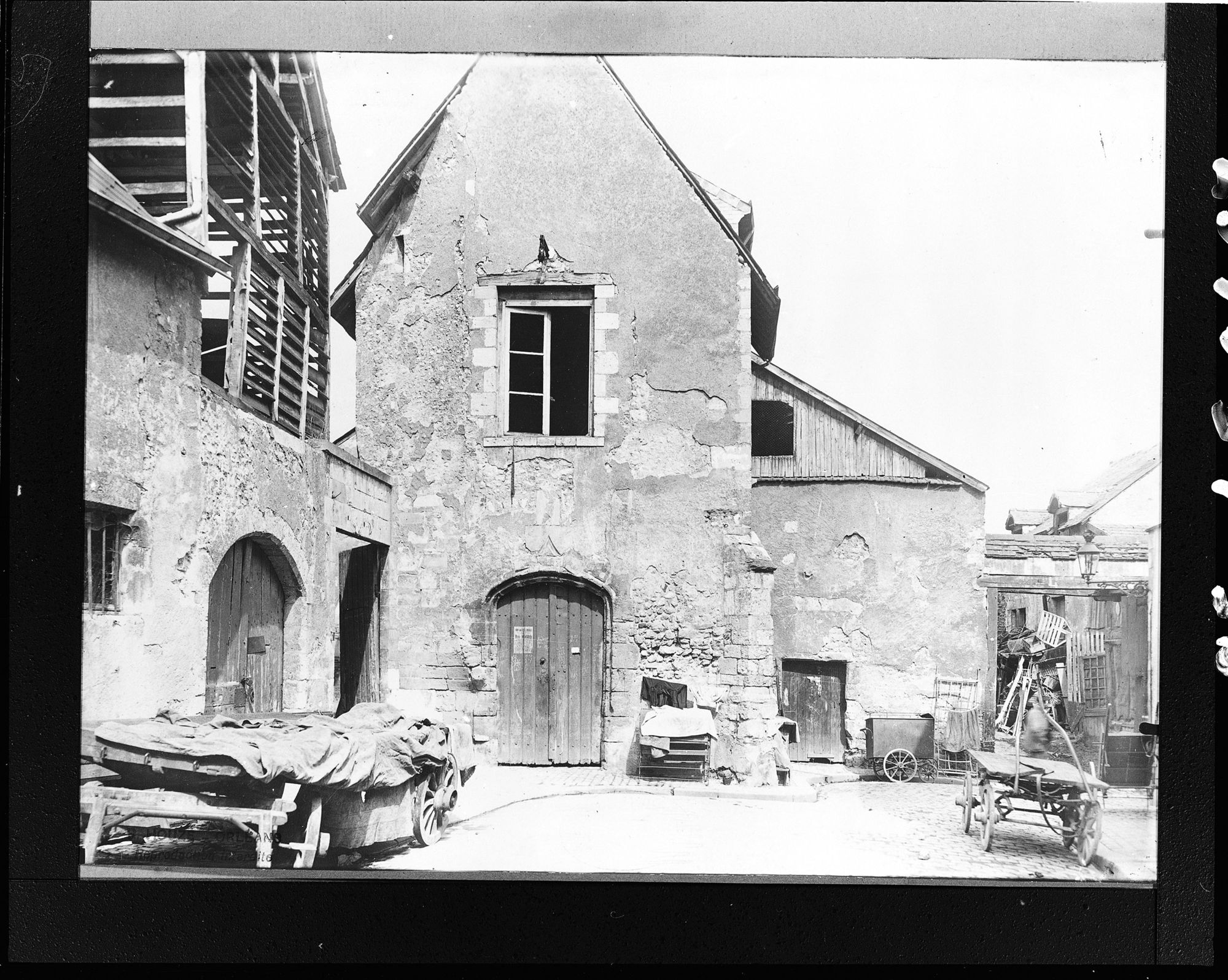 Cloître Saint-Benoît, ancienne église de Saint-Benoît du Retour, en 1913 (photographie de  René Houzé, SAHO, 1913, ADL, 7 FI 293, cl. ADL). A gauche, magasins avec séchoirs au-dessus. 