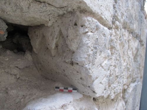 Vue d'un fragment de corniche sculptée d'une frise de dents-de-scie sur la façade nord de la maison " romane " (crédits : Pôle d'archéologie, 2015)