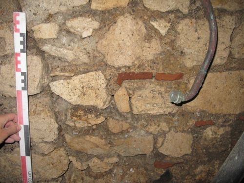 Vue de détail du mur sud de la cave médiévale, avec remploi de tuiles à rebord antiques (crédits : Pôle d'archéologie, 2015).