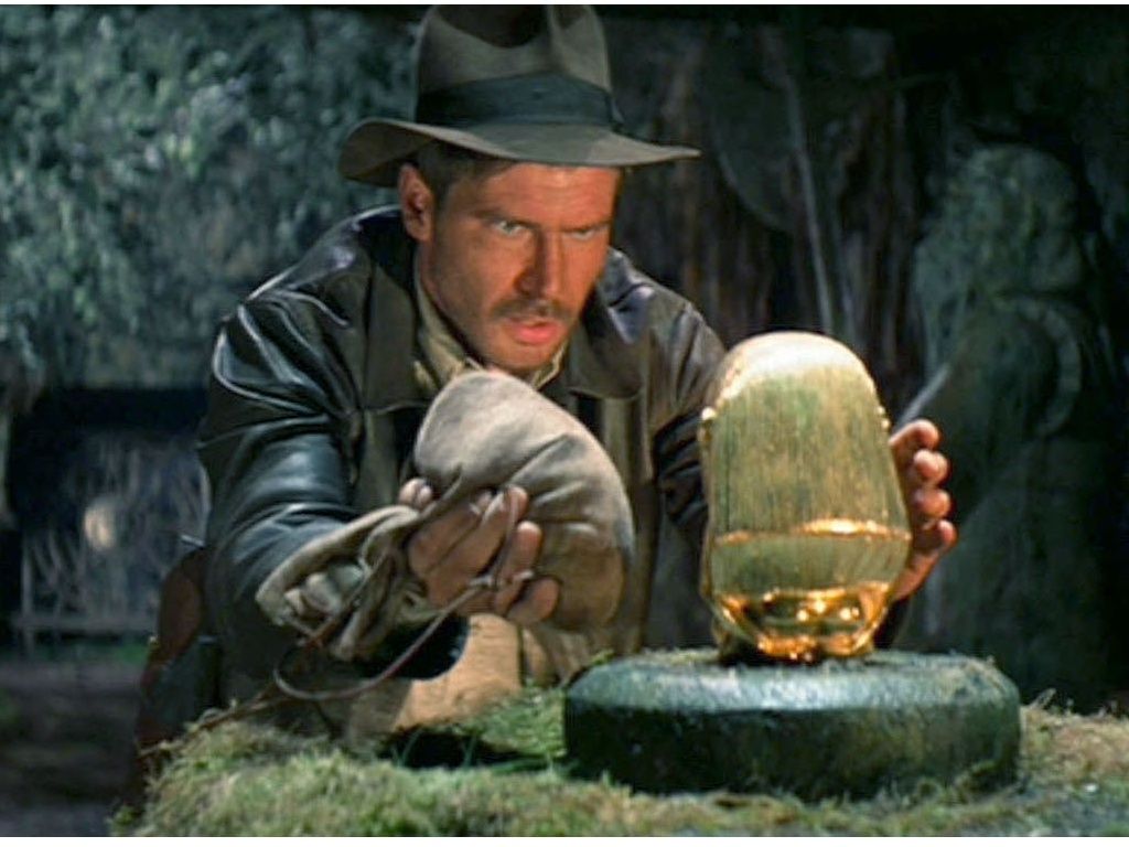 Indy court derrière les statuettes en or et les objets aux pouvoirs bibliques.